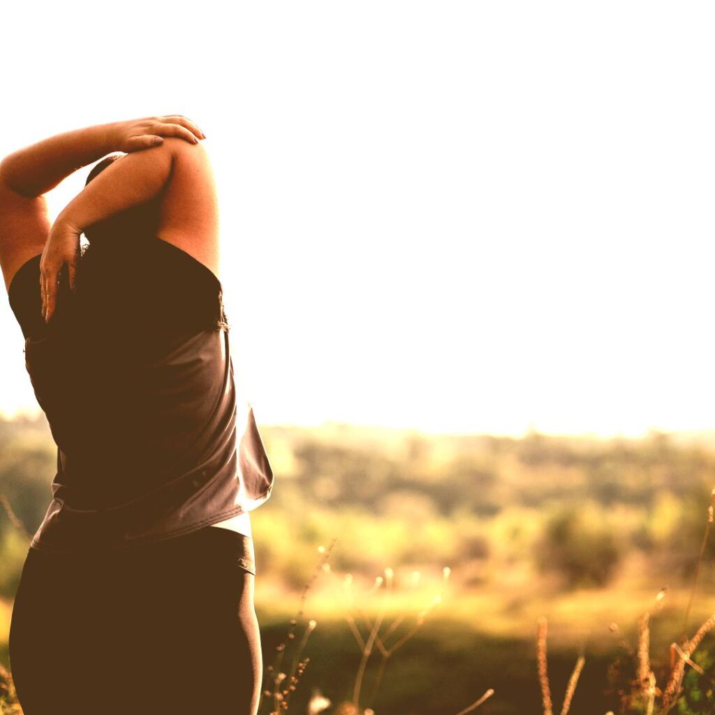 A woman stretching outdoors in the sunshine