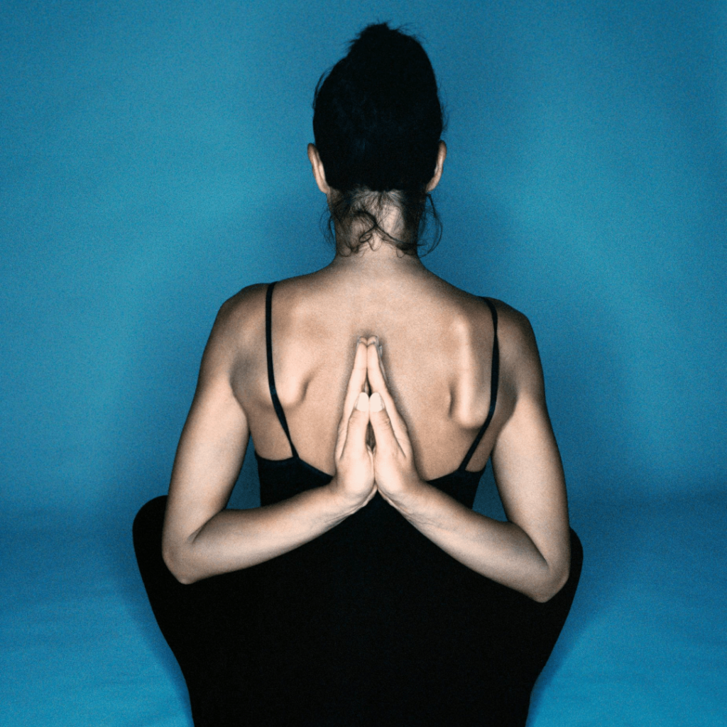 A woman in a yoga pose with hands behind her back