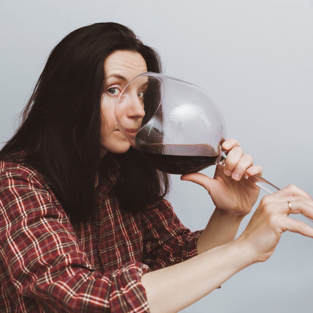 Woman drinking from a HUGE glass of wine as a metaphor for an unhealthy diet.