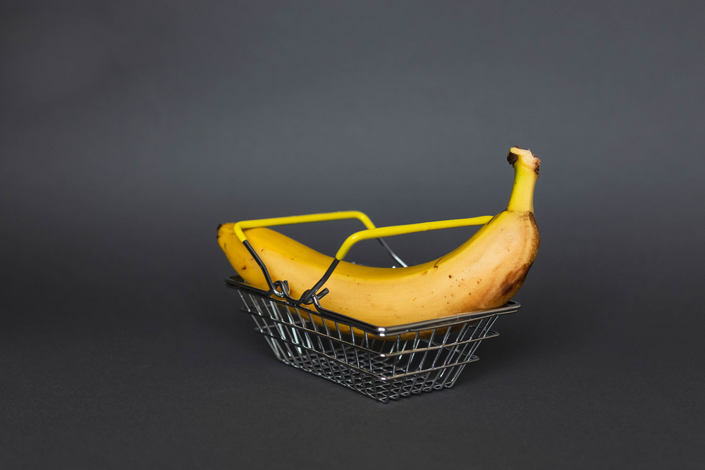 A big banana in a shopping basket as a metaphor for managing blood sugar levels and dieting